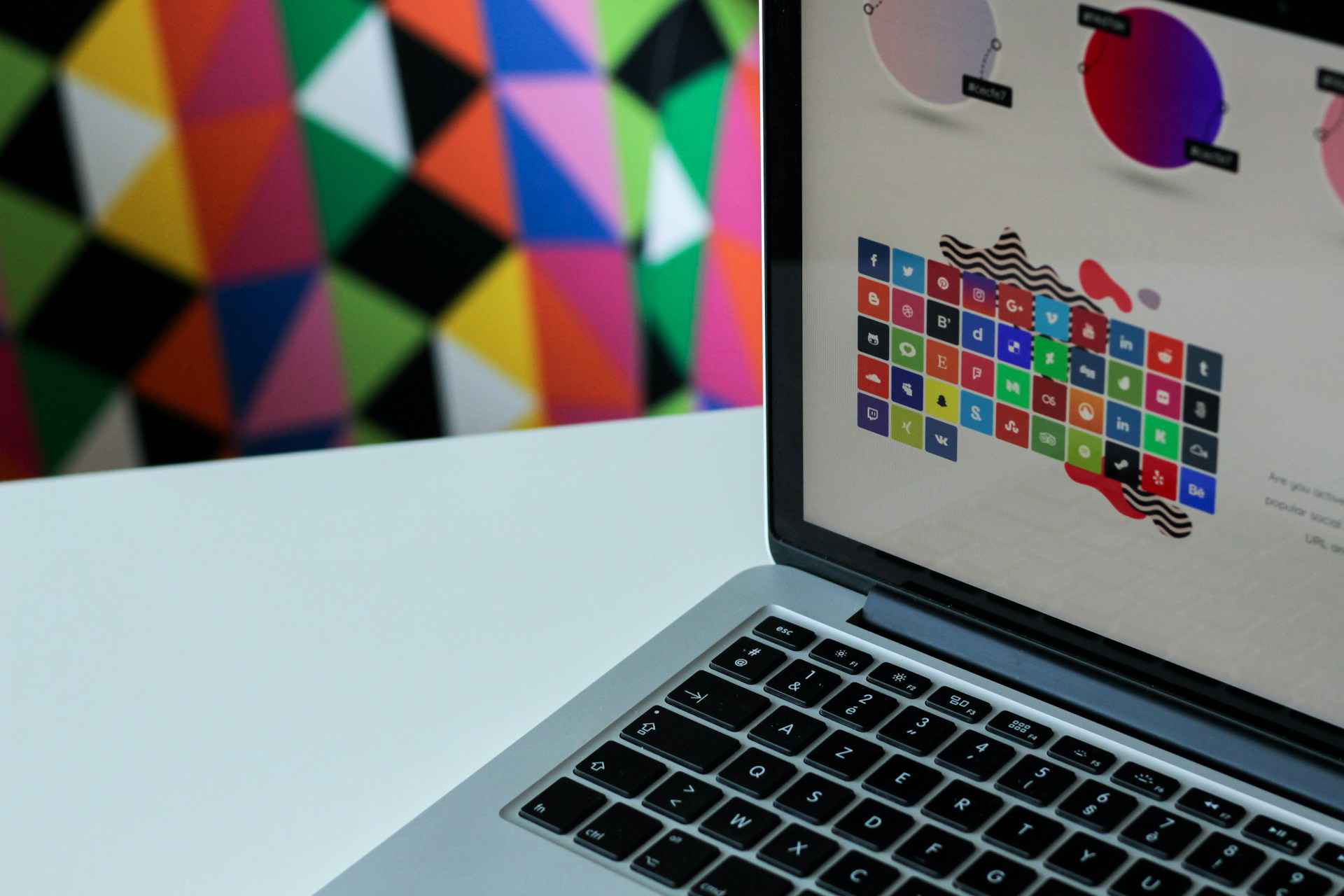 Un laptop abierto mostrando una presentación de sistemas de diseño con una serie de colores y bloques de construcción de interfaz de usuario en la pantalla, sugiriendo la planificación y estructura detrás del diseño de productos digitales.