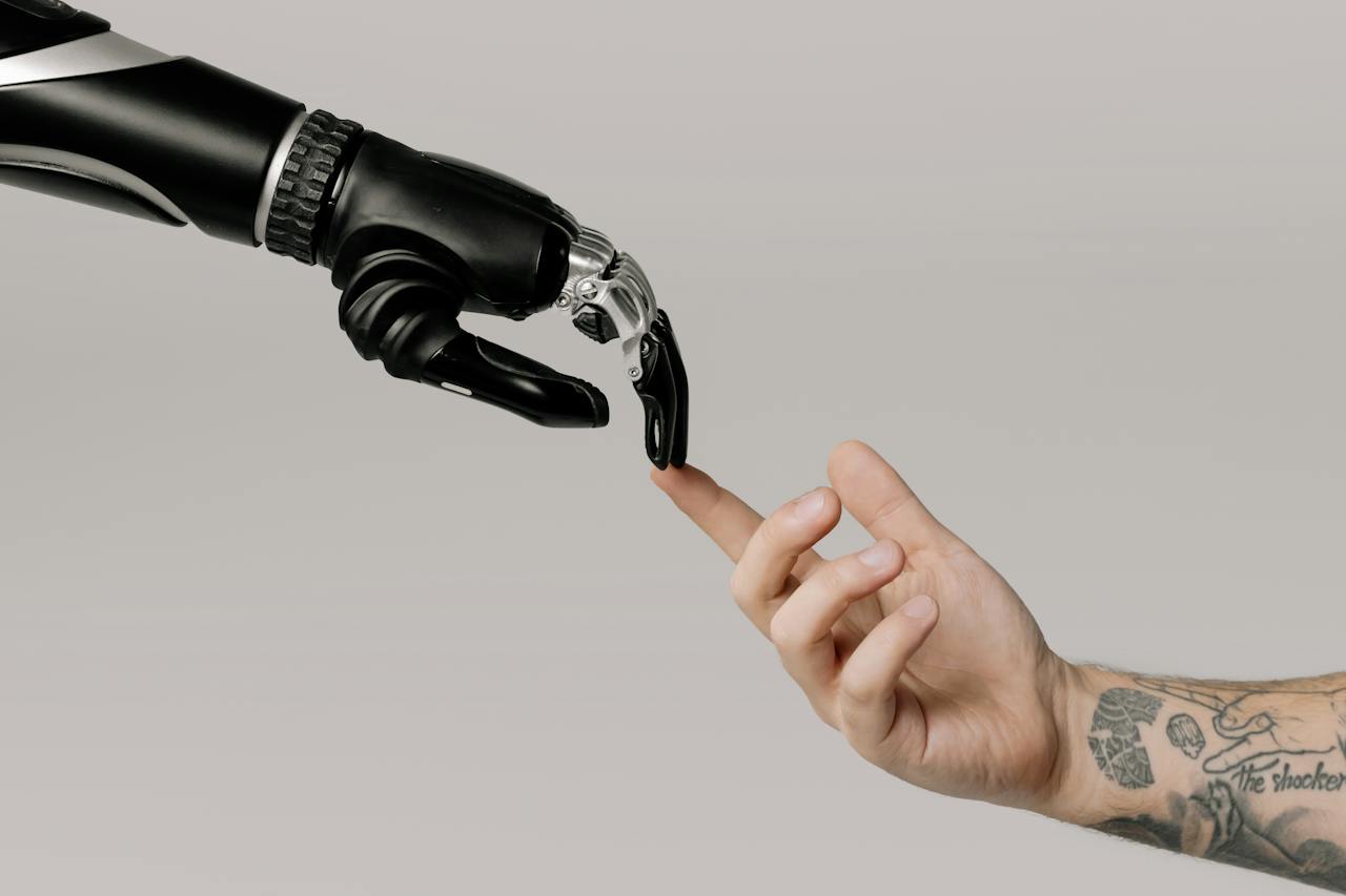 Interacción entre una mano humana y una mano robótica con dedos articulados, simbolizando el avance de la tecnología en robótica y la interacción entre humanos y máquinas.